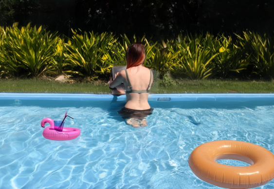 woman sitting in a swimming pool working